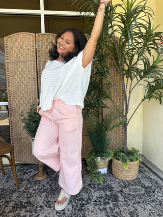 White textured dolman top with short sleeves paired with pink wide-leg pants.
