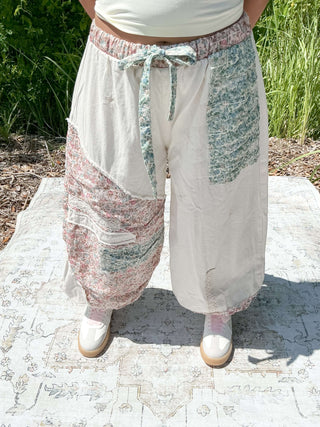 Ivory jogger pants with a floral patchwork design and elastic waistband for a relaxed fit