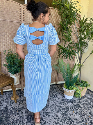 Blue and white striped midi dress with puff sleeves and open back bow detail.
