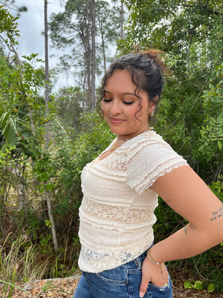 Cream lace short-sleeve top with tiered horizontal lace panels and v-neckline.
