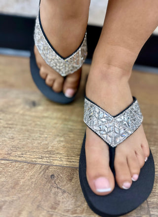 Black thong sandals with silver glitter upper straps and black wedge sole.
