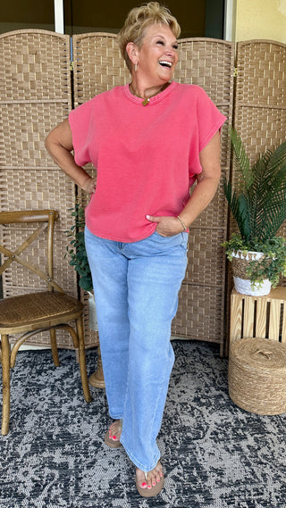 Hot pink oversized drop shoulder tee with rolled sleeves paired with light blue jeans.
