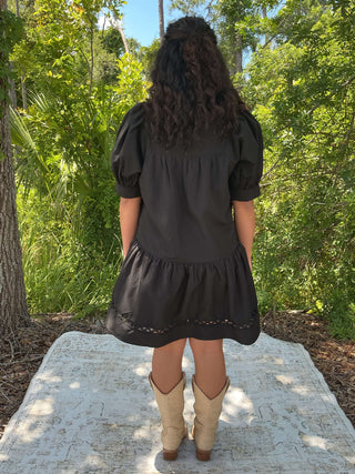 Black short sleeve dress with scallop trim and pockets, perfect for casual or semi-formal occasions