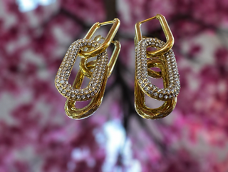 Gold-plated link earrings with crystal rhinestone pavé detailing and oval carabiner design.
