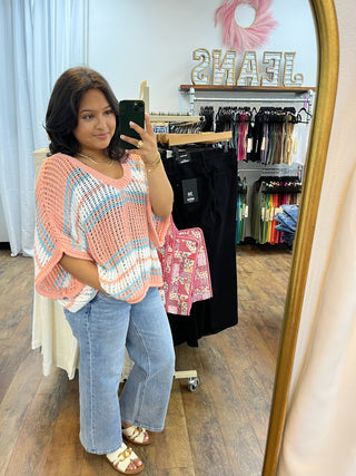 Coral and aqua striped crochet short-sleeve top with openwork pattern, worn with blue jeans.
