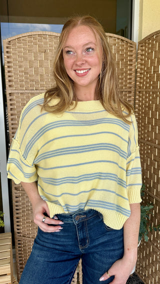 Yellow and blue striped short-sleeve knit sweater with crew neckline on model.
