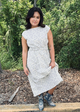 Ivory & blue boat neck sleeveless pleated midi dress with floral design, perfect for a stylish and elegant look.