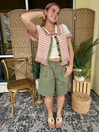 Pink and white striped knit cardigan with short sleeves worn over white tank top.
