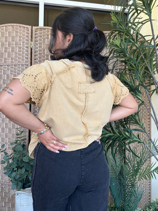 Cream oversized short-sleeve top with eyelet crochet sleeves and back lace-up detail.
