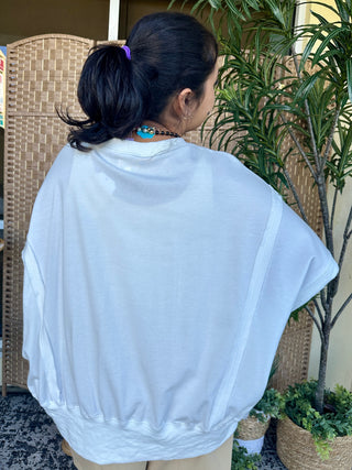 Light blue oversized terry cloth top with short sleeves, worn back view showcasing relaxed fit.
