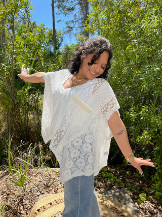 White lace short-sleeve top with handkerchief hem and geometric floral pattern details.
