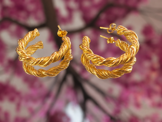 Gold twisted hoop earrings with textured rope design and stud posts.
