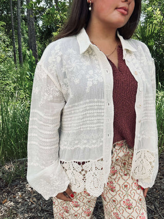 Ivory long sleeve button-down top with crochet hem and embroidery, offering a chic and elegant look for any occasion.