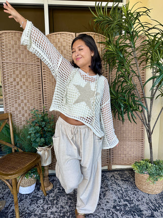 Ivory open weave mesh cropped long-sleeve top with textured knit pattern worn with cream pants.
