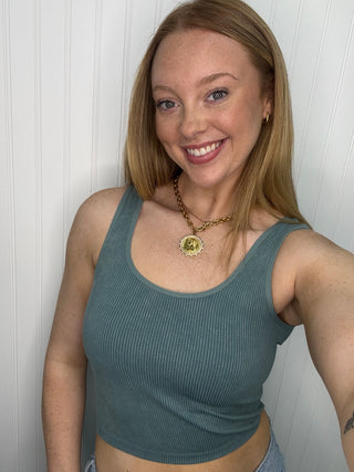 Blue ribbed sleeveless tank top with scoop neckline on model.
