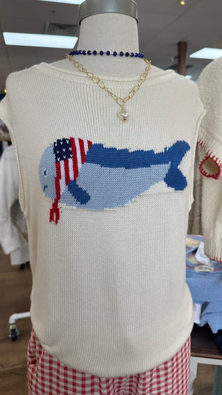 Cream sleeveless sweater with blue whale and red striped flag intarsia design.
