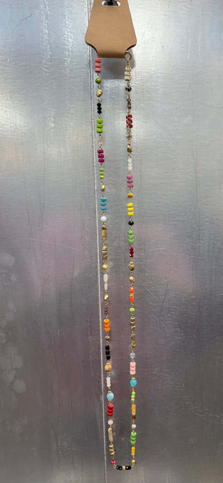 Alt text: "Gold multicolor donut and glass bead long necklace with vibrant pendant accents.