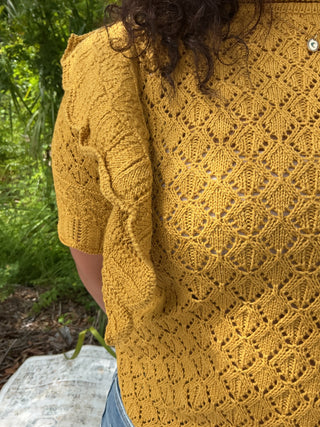 Light pink pointelle knit top with ruffle sleeves and a relaxed fit