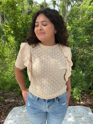 Light pink pointelle knit top with ruffle sleeves and a relaxed fit