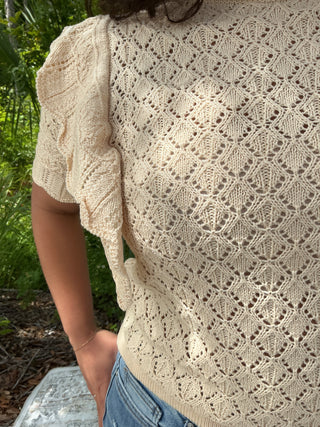 Light pink pointelle knit top with ruffle sleeves and a relaxed fit
