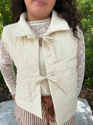 Ivory quilted vest with floral embroidery and a tie front detail
