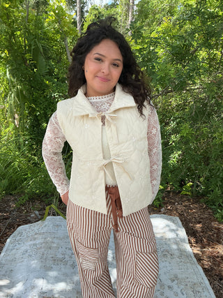 Ivory quilted vest with floral embroidery and a tie front detail