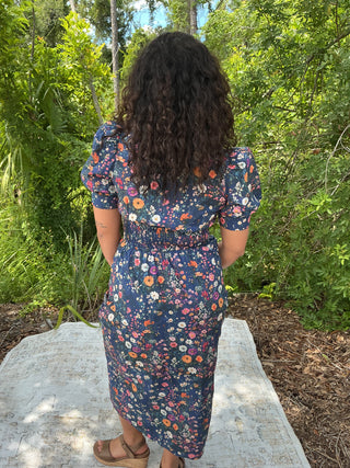 Navy floral print dress with puff sleeves, zip front, and smock waist detail