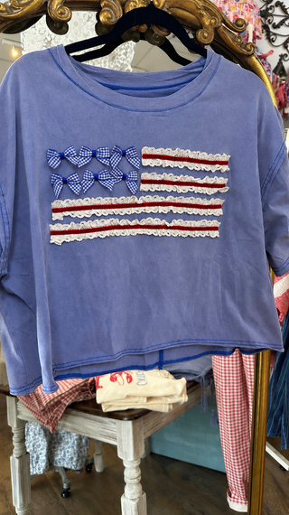 Periwinkle blue oversized sweatshirt with gingham heart and ruffled stripe American flag design.
