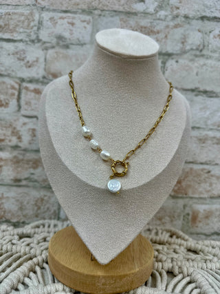 Gold paperclip chain necklace with freshwater pearls and circular pendant on display bust.
