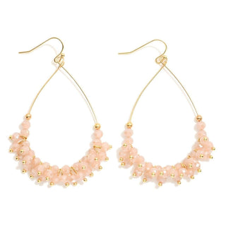 Elegant pink and gold faceted bead teardrop earrings add a touch of glamour to any outfit; perfect for special occasions.
