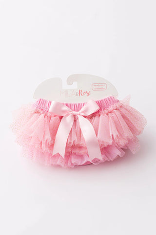 Pink tulle ruffle bloomer with white ribbon bow and elastic waistband, displayed on branded hanger.
