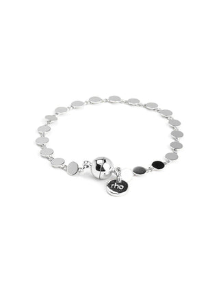 Silver dot disc bracelet with magnetic closure and dangling charm detail.
