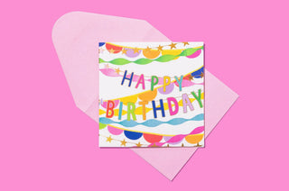 Colorful Happy Birthday greeting card with multicolored bunting and confetti pattern on white envelope.
