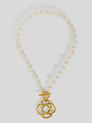 Cream pearl beaded necklace with gold-tone interlocking clover charm pendant.
