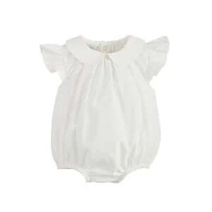 Baby wearing MudPie White Collared Poplin Bubble, featuring decorative buttons and ruffle sleeves, sitting in a stylish room.