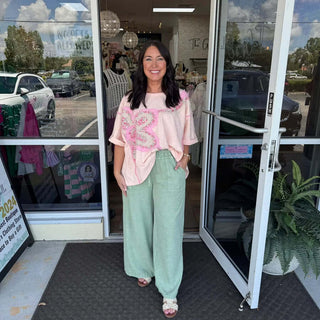 Woman wearing Blush Flower Patch Mineral Wash Top Easel, featuring floral designs and a relaxed fit, perfect for casual outings.