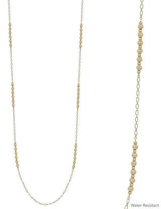 Gold bead and dainty chain long necklace elegantly displayed on a minimalistic white background. Perfect for modern styling.