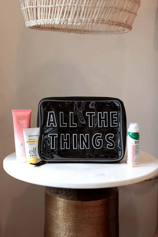 Jadelynn Brooke Black Oversized Cosmetic Bag labeled "All The Things" with a sleek zipper and durable fabric design.