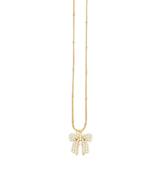 Gold pearl bow necklace by Lauren Kenzie with a lifetime warranty, set against a subtle white background.